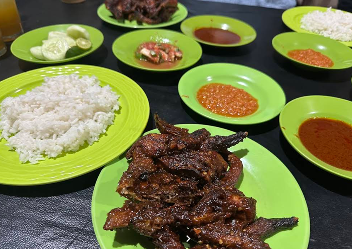 ayam taliwang gambar beberapa piring berisi sambal nasi lalapan dan ayam taliwang