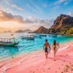 pasangan berlari menuju ombak untuk surfing di pantai pink lombok dengan pasir merah muda alami