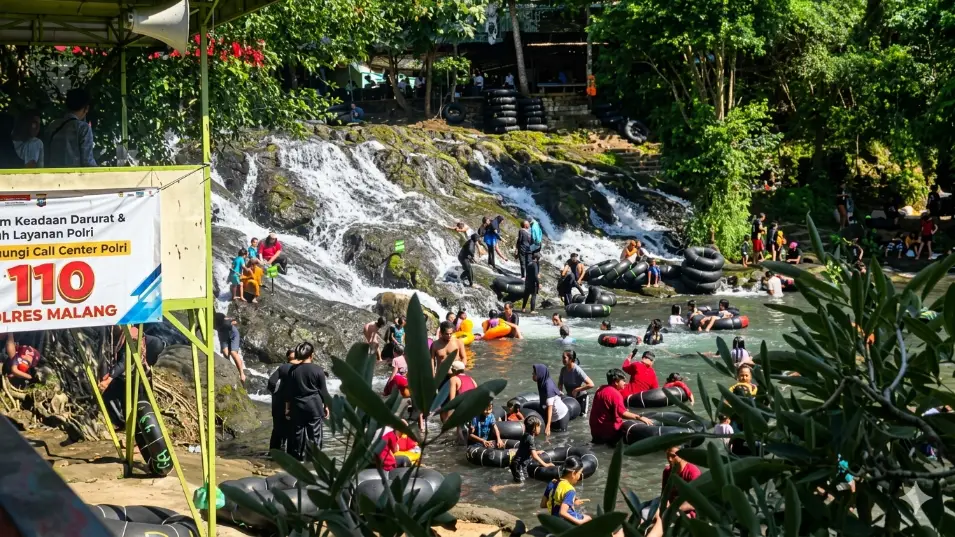 orang-orang sedang rive tubing di sumber maron malang
