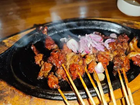 sate paino malang dengan taburan bawang merah di atasnya dan diletakkan di atas hotplate