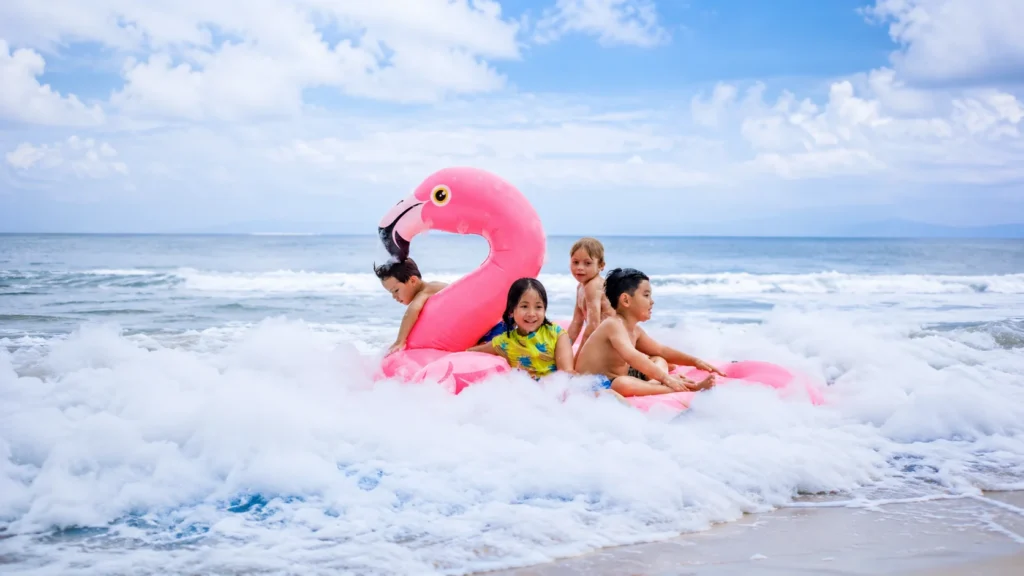 foam party di flamingo beach club. anak-anak sedang bermain di pantai dengan ban flamingo