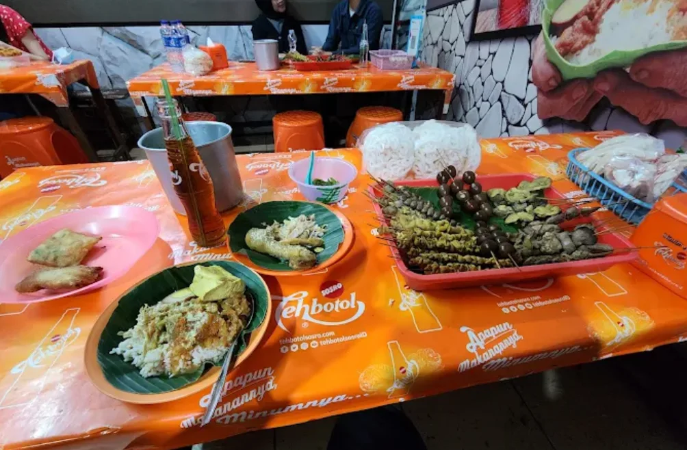 Nasi Ayam Bu Wido diatas meja oranye dan sebotol teh