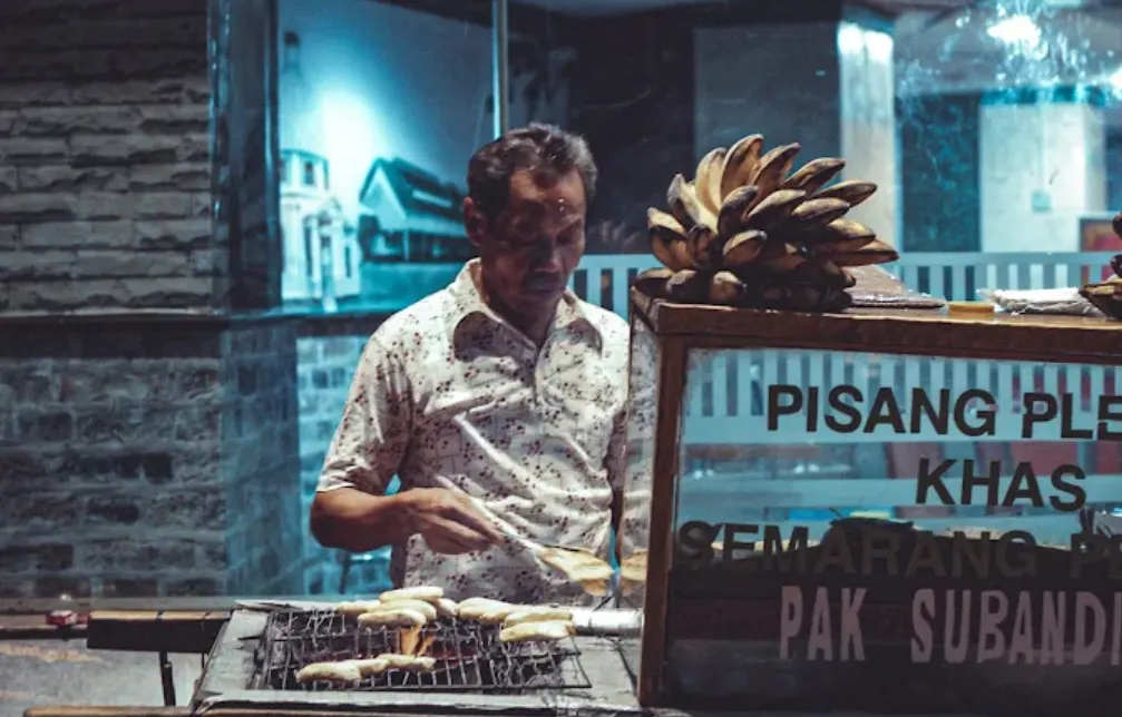 foto seorang bapak berjualan dengan gerobak Pisang Plenet Pak Subandi
