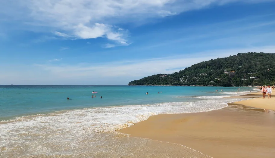 pantai phuket saat siang hingga sore hari, cuaca cerah, dan banyak orang berenang